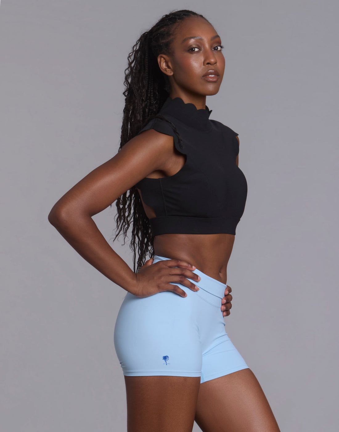 Woman wearing black and light blue The Palm activewear in the studio