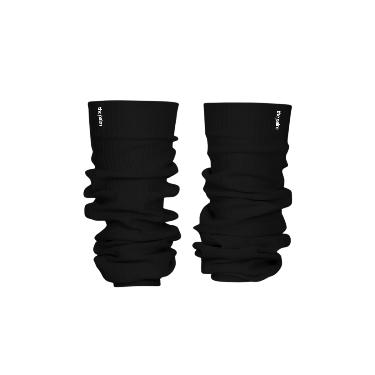 Ivory ribbed knit leg warmers by The Palm, featuring a minimalist logo tag and soft slouchy texture on a jet black background