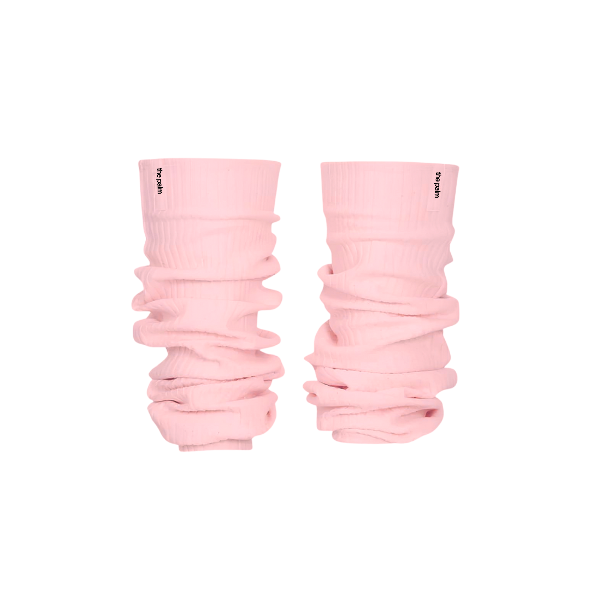 Ivory ribbed knit leg warmers by The Palm, featuring a minimalist logo tag and soft slouchy texture on a powder pink background.1