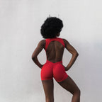 Model with afro hairstyle in red sculpt romper, back view — The Palm activewear
