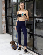 Full-length front view of woman taking photo with dog wearing high-waist dark blue LiftLine sculpt leggings and black bra