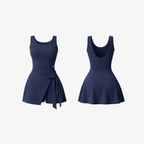 The Palm DrapeFit™ Wrap Romper in Midnight Navy. A sculpting activewear romper featuring a feminine wrap-skirt detail, built-in shorts, and a sleek silhouette designed for movement, comfort, and effortless confidence.