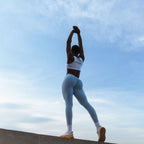 Activewear set by The Palm. White seamless bra and sky blue leggings, stretching under morning sky.